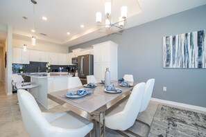A modern kitchen with white cabinets, stainless steel appliances, and a central island. - IL405 Storey Lake Condo 2 bed 2 bath  Free Waterpark (Kissimmee)