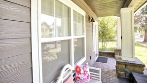A covered porch with a bench, a door, and a window. - Family home downtown CDA walk to lake and dining (Coeur d'Alene)