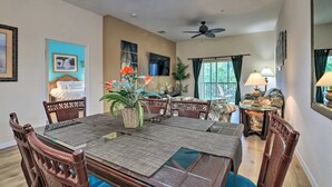 A dining area with a large table, chairs, and a ceiling fan.