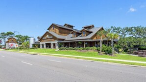 A large, rustic building with a sign reading "Dunstan Winery." It features a covered outdoor seating area and is surrounded by greenery.