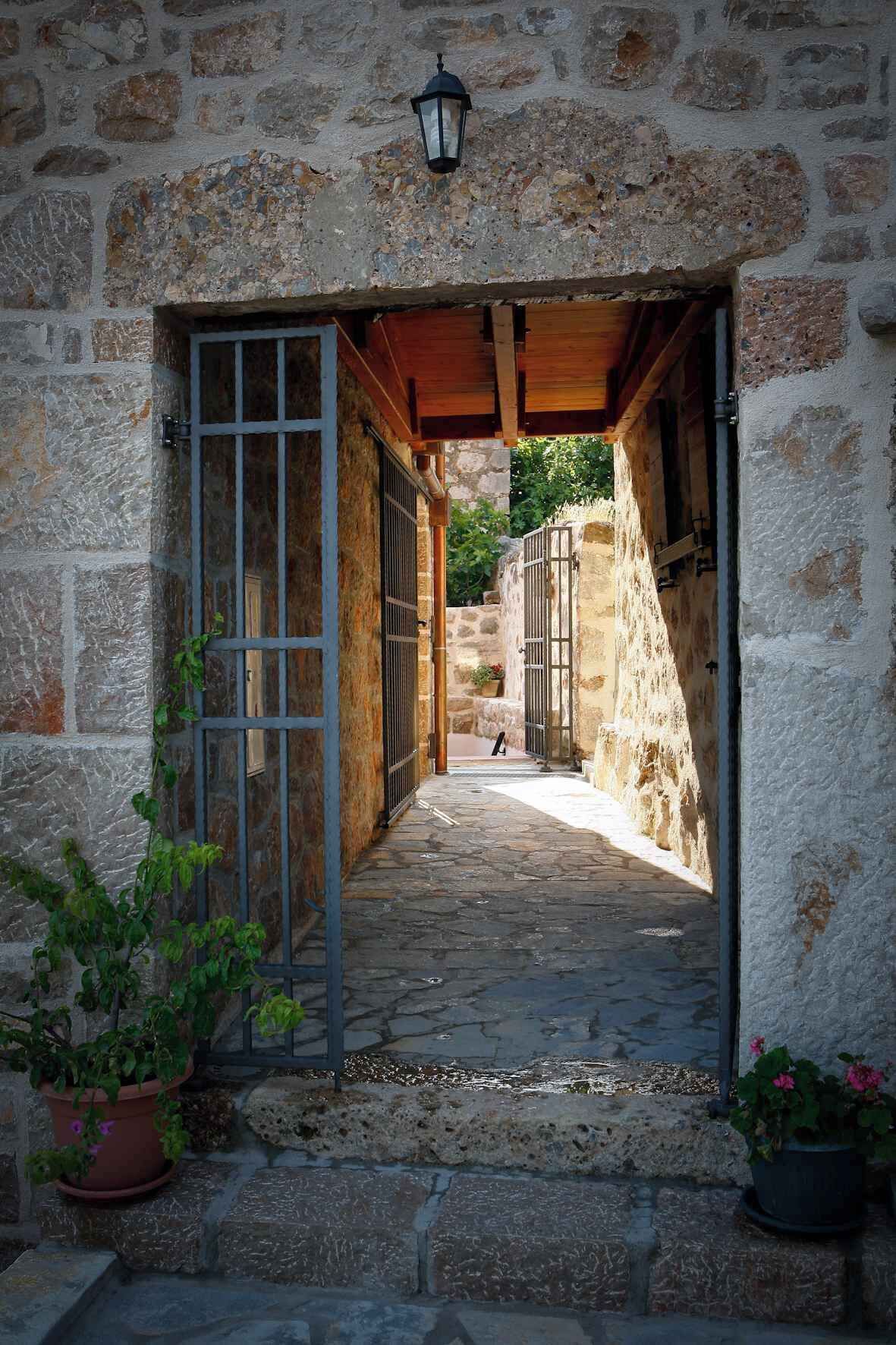 A stone building with a narrow passageway leading to a courtyard.