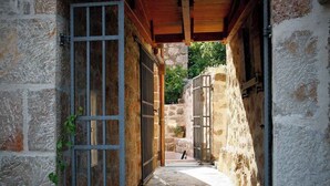 A stone building with a narrow passageway leading to a courtyard. - Holiday home mit Klimaanlage und Terrasse (Starigrad-Paklenica)