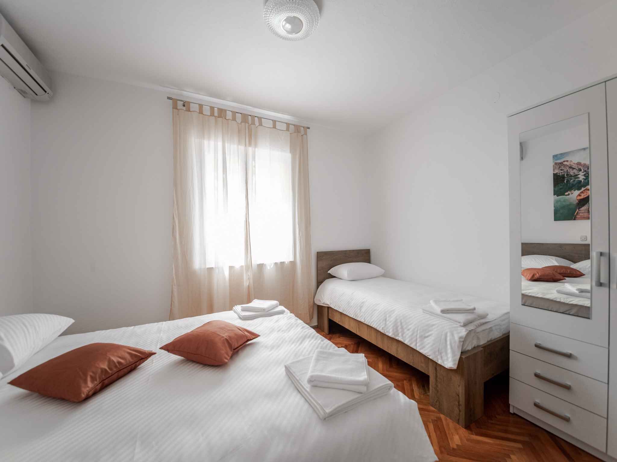 Un dormitorio con dos camas, un armario y una ventana con cortinas.