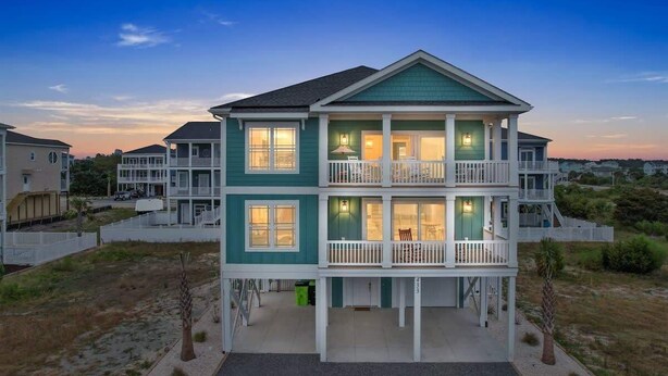 A two-story beachfront house with a balcony, a covered front porch, and a view of the beach. - A Wedge Away by Brunswick Vacation Rentals: Near Beach, Great Views, Heated Pool (Ocean Isle Beach)
