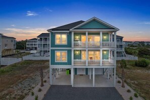 A two-story beachfront house with a balcony, a covered front porch, and a view of the beach. - A Wedge Away by Brunswick Vacation Rentals: Near Beach, Great Views, Heated Pool (Ocean Isle Beach)