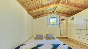 A bedroom with a wooden ceiling, a window, a bed with pillows, and a wardrobe. -  Kipi Village Zakynthos (Ζάκυνθος)