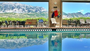 Ein Poolbereich mit Liegestühlen und Blick auf die Berge.