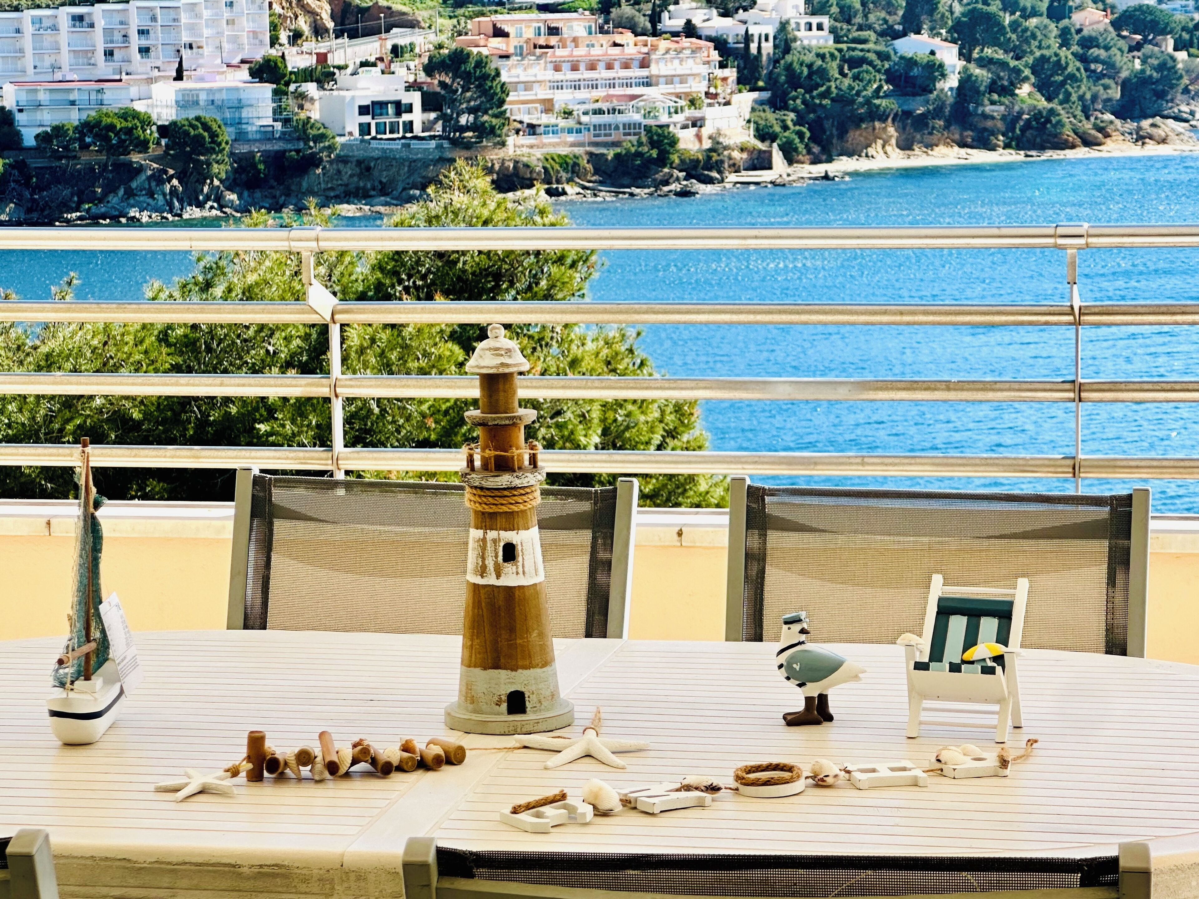 A table with a model ship, a lighthouse model, and a bird figurine.