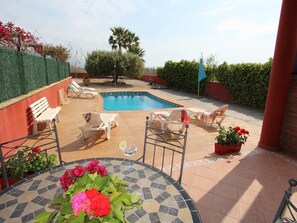 A pool area with lounge chairs and a table with flowers. - CASA SARSET, Ideal house for your holidays near the sea, free wifi, optional air conditioning, private pool, pets allowed, dog’s beach (Delta de l'ebre)