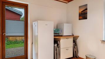 A compact kitchen with a refrigerator, microwave, and a small countertop.