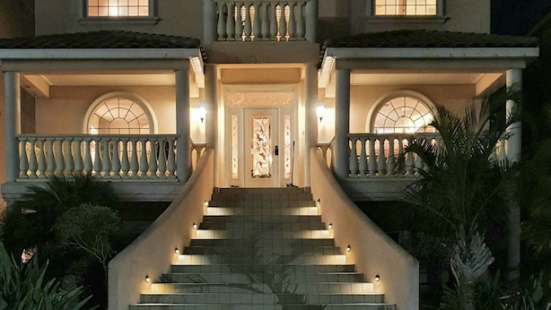 Una amplia casa de dos pisos con una entrada imponente, una escalera y un balcón.