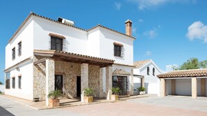 A two-story house with a stone facade, a tiled roof, and a covered patio area. - Chalet "Casa Juan Arias" Close to the Sea with Pool, A/C, Wi-Fi, Garden & Terrace (Conil de la Frontera)