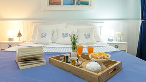 A neatly made bed with a tray of breakfast items, a lamp, and a framed picture on the wall. - Vacation Apartment "Appartamento degiorgio8" with Terrace & Wi-Fi (ALGHERO)