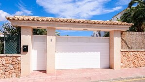 Un bâtiment doté d’une entrée abritée, d’une porte de garage et d’un mur en pierre.