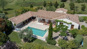 A large house with a swimming pool, multiple rooms, and a garden.