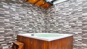 A spa room with a wooden hot tub, a wooden bench, and a tiled wall. - 3 Bedroom PH Hot Tub Sliding Roof AC (Medellin)