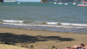 A beach with boats in the water, a large cruise ship, and a rocky shoreline. - One week (7 to 14 Jan. 2023) in Club Paihia award winning resort  (Paihia)