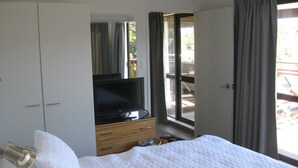 A bedroom with a bed, a TV, a wardrobe, and a window with curtains. - One week (7 to 14 Jan. 2023) in Club Paihia award winning resort  (Paihia)