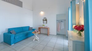 A modern room with a blue sofa, a small round table, a wooden console table, a mirror, and a vase with flowers. - Seaside, near the elevator, just a few steps away, and parking available (Positano)