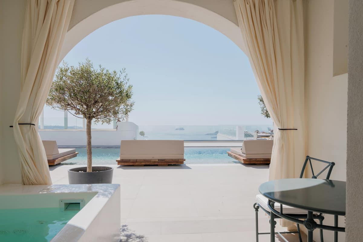 Terraza en la azotea con piscina, sillas de descanso y una mesa.