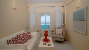 Suite studio exécutive, baignoire à remous (Caldera View) | Aire de séjour | Téléviseur à écran plat de 35 po avec télévision numérique, téléviseur