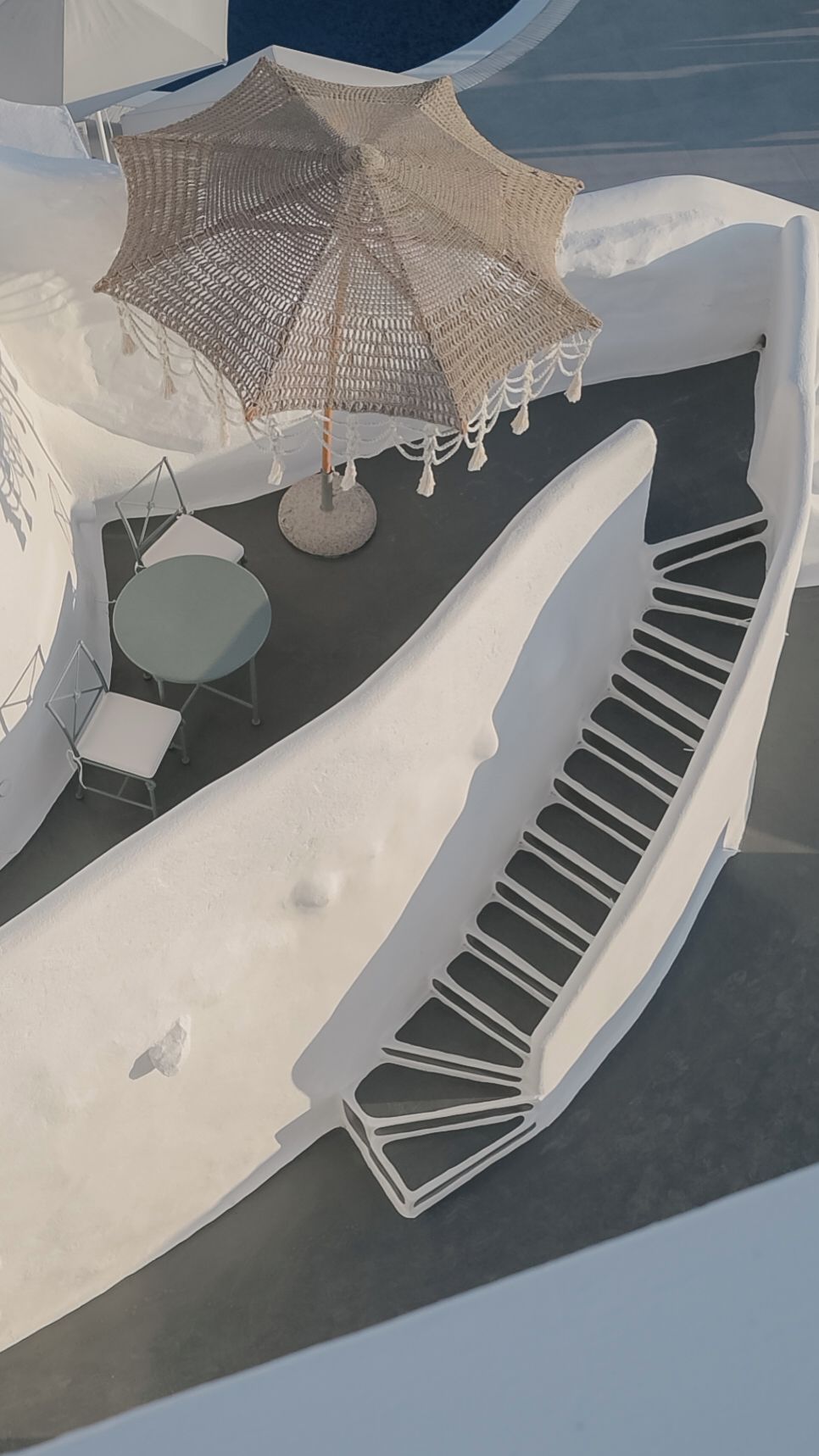 Un área de estar al aire libre y de diseño moderno con una mesa redonda y sillas, un parasol tejido y un diseño de silla único.