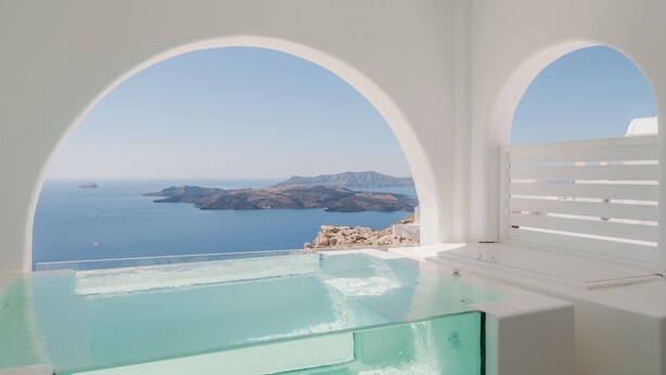 A modern infinity pool with a clear view of the sea and distant islands. - Apeiron Blue by Apeiron Hotels (Santorini)