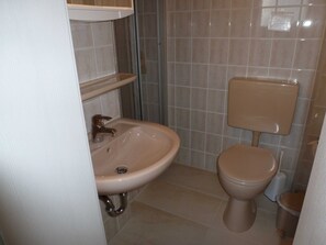 Ein Badezimmer mit Waschbecken, Toilette und Fliesen.