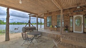 A covered outdoor area with a grill, seating, and a view of a lake. - Secluded Angler's Haven - Boat + Fish! (Rosston)