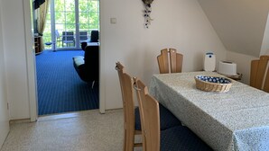 Un comedor con una mesa preparada para dos personas, una cesta de pan y un tostador.