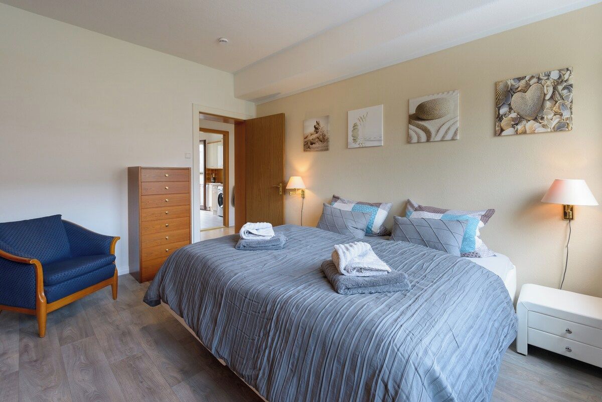 Schlafzimmer mit Doppelbett und Sessel