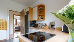 Una cocina moderna con estufa integrada, microondas y armarios de madera.
