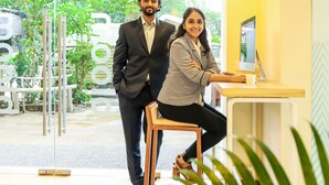 A modern office interior with glass doors leading to an outdoor area, a desk with a computer, and a chair. - Bloom Hotel - Worli (Mumbai)