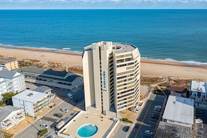 A high-rise hotel with a pool and beach view.
