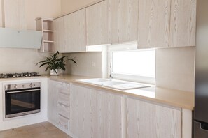 Een koelkast, een oven, een kookplaat, een koffiemolen