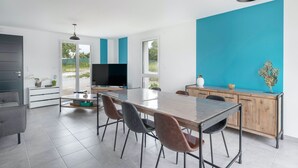 Una cucina moderna con un grande tavolo da pranzo, sedie e un televisore.