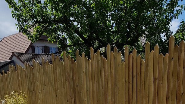 A wooden deck with metal chairs and a table, surrounded by a wooden fence. - Maison Plein Coeur de Ouistreham Riva Bella (Ouistreham)