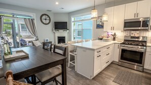 A modern kitchen with white cabinets, a built-in oven, and a large island. - Beachwalk Resort Cottage with Pool Access/Golf Cart (Michigan City)