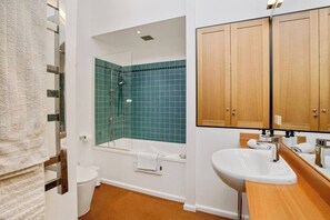 Un baño con ducha, inodoro y lavamanos.