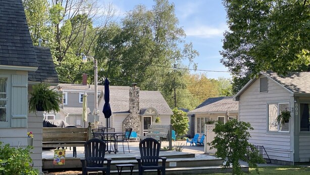 A patio area with outdoor furniture, a stone fireplace, and a view of neighboring houses.