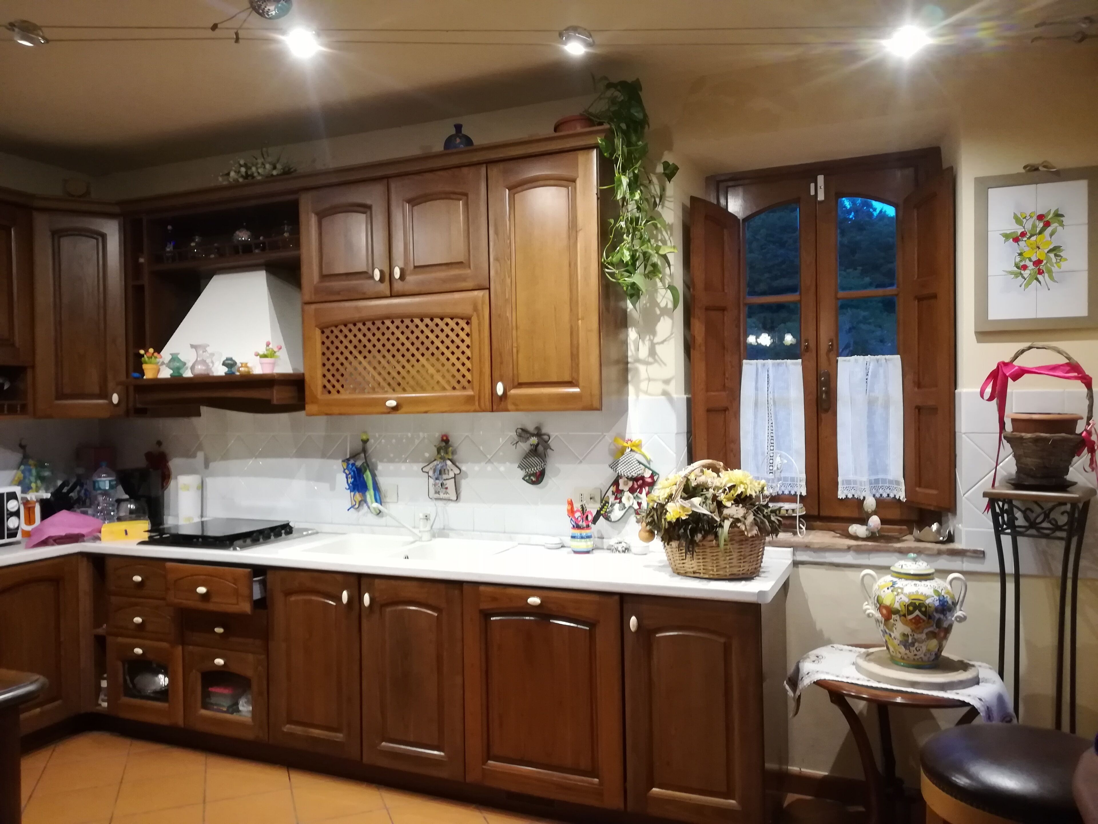 A kitchen with wooden cabinets, a white countertop, and various kitchen items.