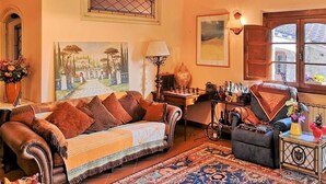 A cozy living room with a sofa, armchair, and a chess table.