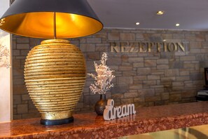 A reception desk with a lamp, a vase with flowers, and a sign that says "dream". - dreams Beckum (Beckum)