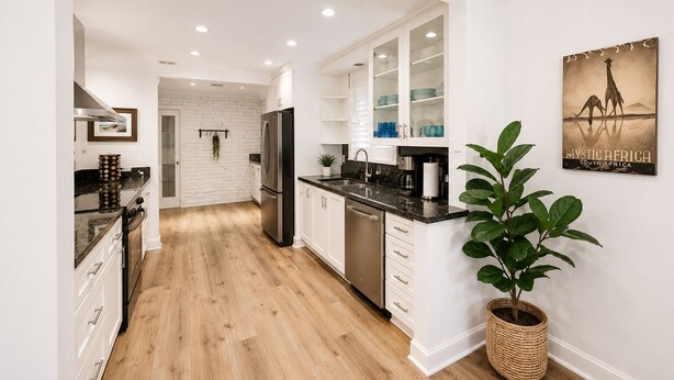 A modern kitchen with white cabinetry, a stainless steel refrigerator, and a wooden floor.