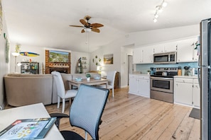 Ett kompakt bostadsutrymme med matplats, kök och sittgrupp.