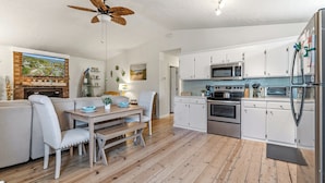 Una cocina moderna con armarios blancos, microondas y refrigerador.