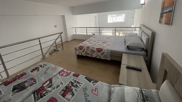 Ein Schlafzimmer mit Bett, Schreibtisch und Balkon.