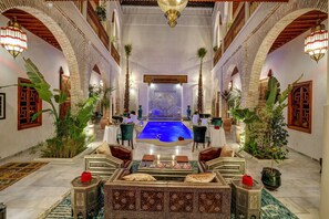 A luxurious interior with a central pool, ornate furniture, and traditional decor. - Riad Janate & SPA - Suite Royale (Marrakesh)