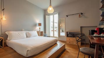 Quarto com cama, mesas de cabeceira, escrivaninha e uma cadeira.