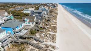 Una propiedad frente a la playa con varias casas, pasarelas de madera y una playa arenosa.